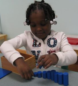 montessori girl w size puzzle Montessori Student with size puzzle